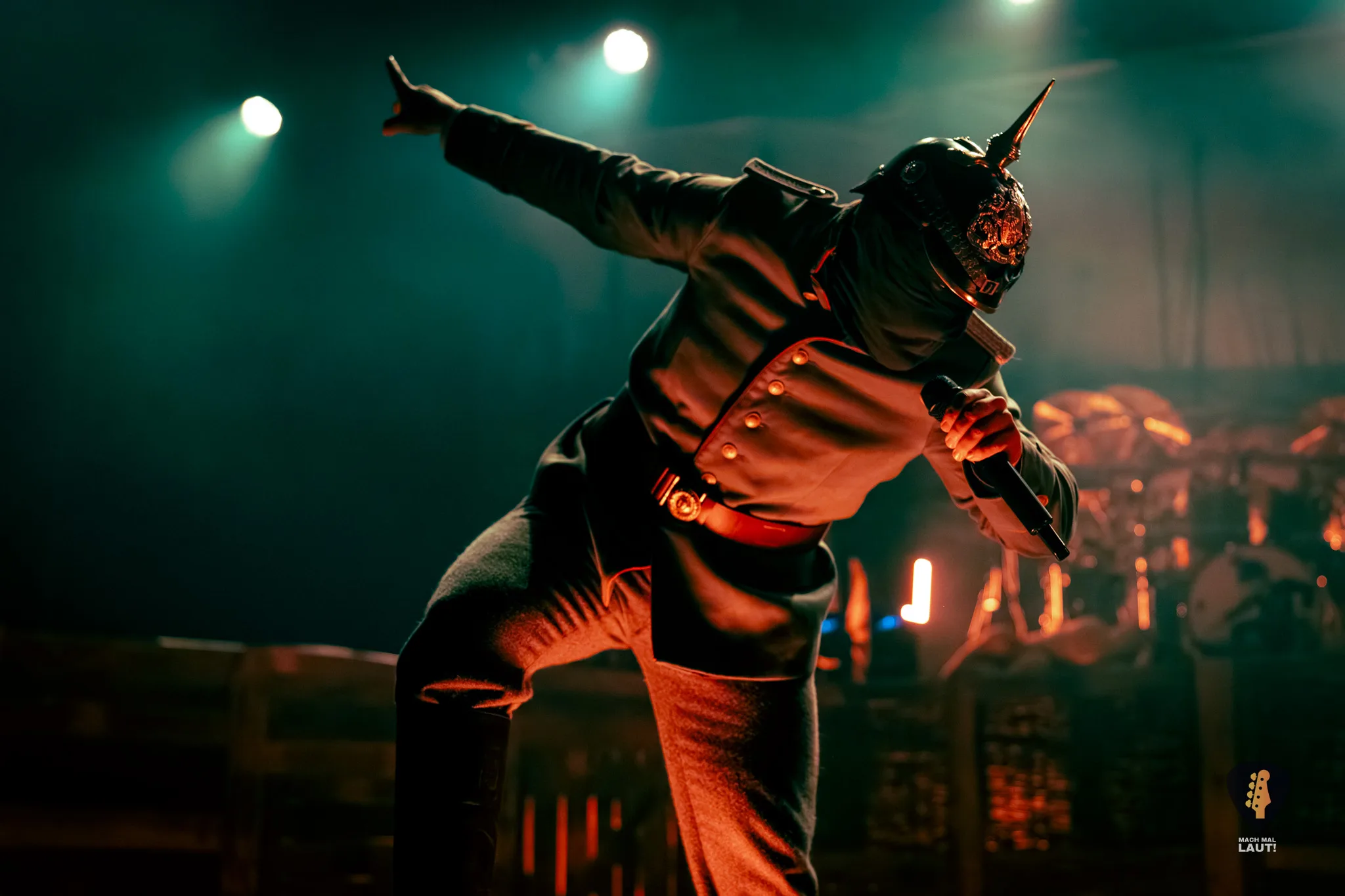 Kanonenfieber Mann in Uniform mit Mikrofon, der von unten rot angeleuchtet wird vor einem nebeligen Hintergrund